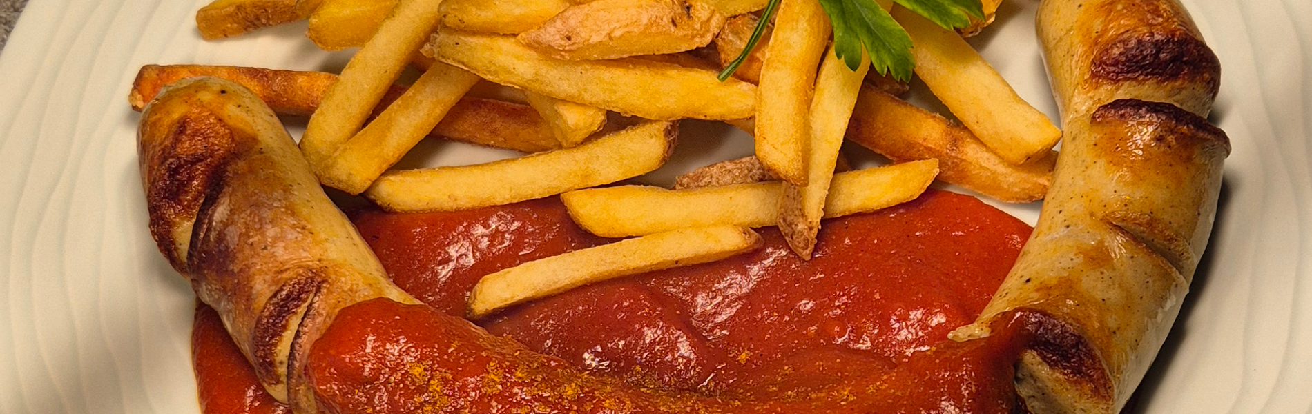 Currywurst mit hausgemachter Currysoße dazu Pommes
