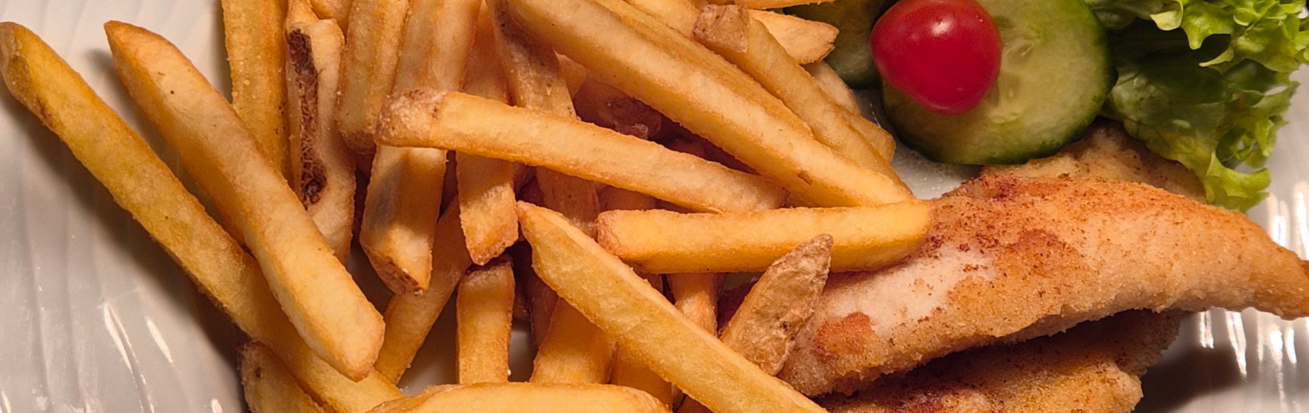 Paniertes Welsfilet mit Pommes und kleinem Salatbouquet