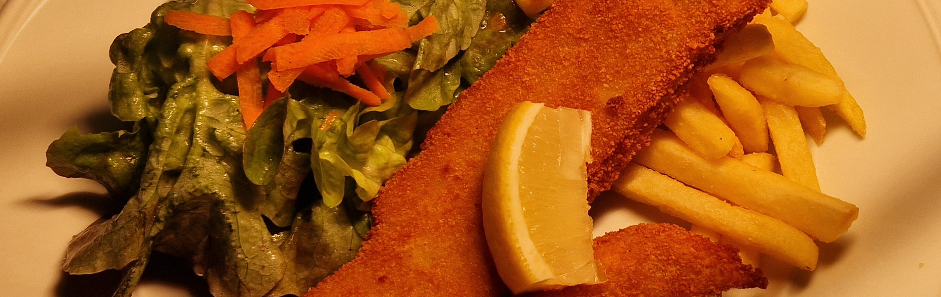 Paniertes Welsfilet mit Pommes und kleinem Salatbouquet